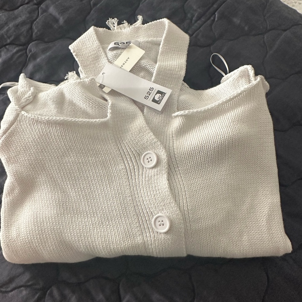 Cold shoulder white sweater with distressed sleeves and hem. New with Tags